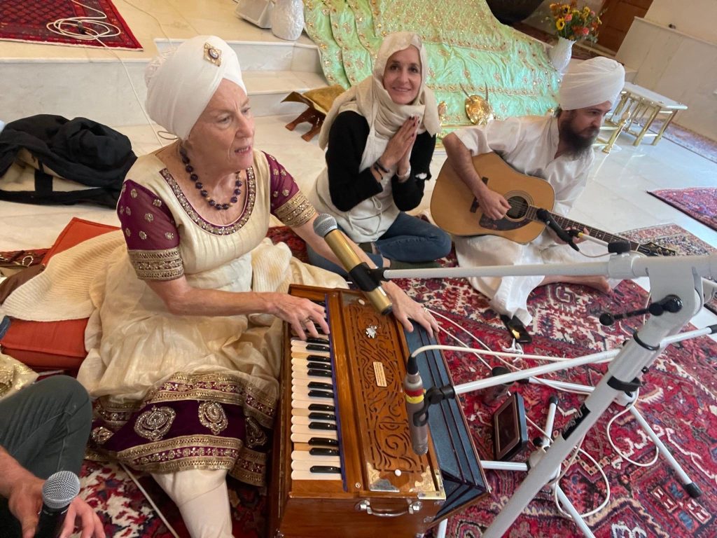 Satkirin Kaur playing kirtan with two Sangat members